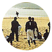 해변가 모래사장에서 유니폼을 입은 선수들이 훈련하는 모습